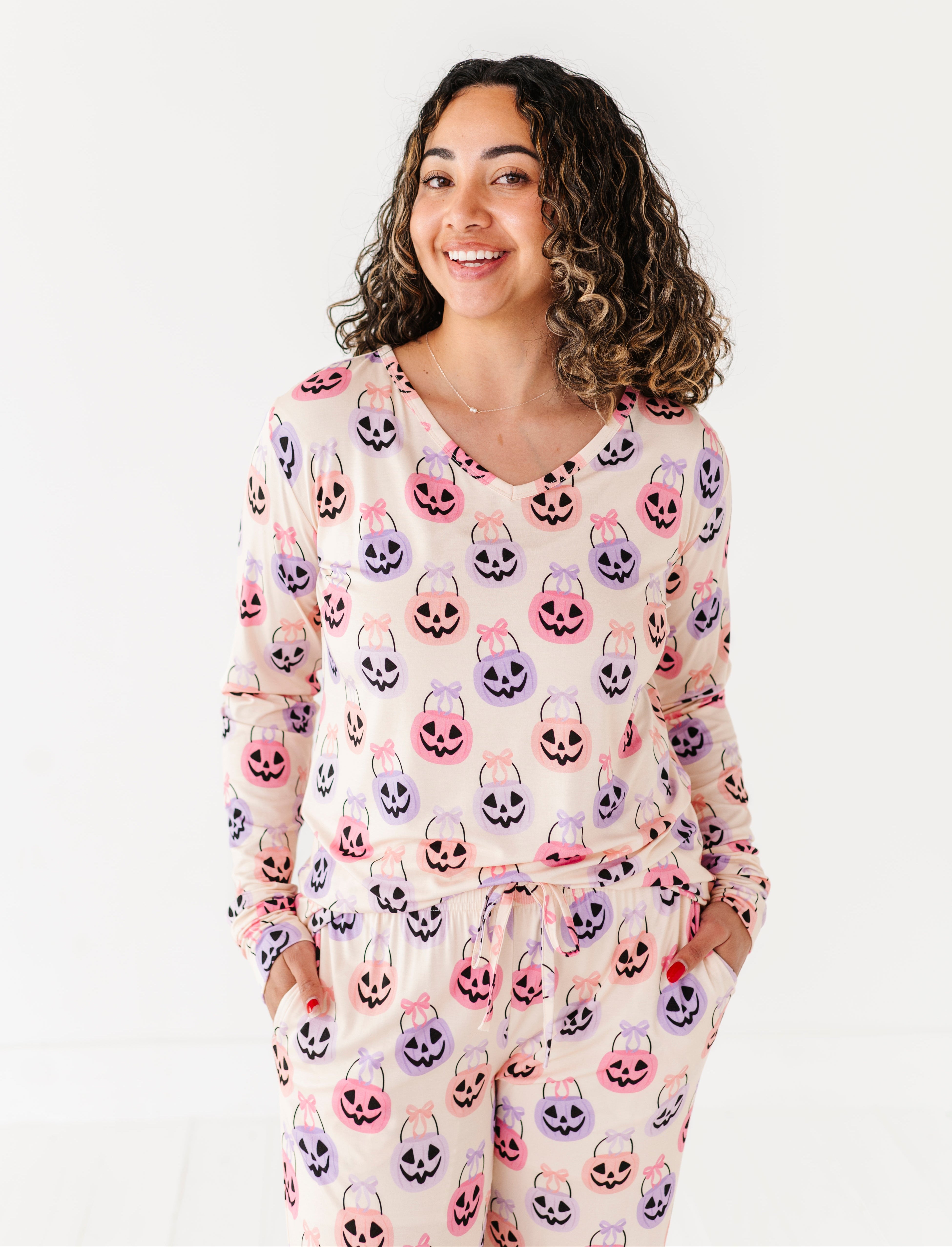 Woman wearing a bamboo pajama set with Halloween-themed candy print on a white background