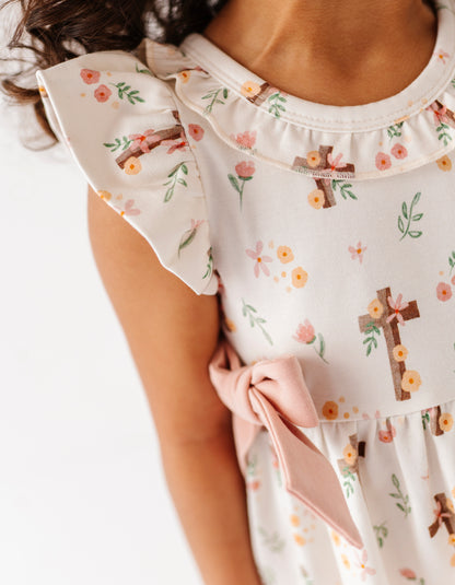 Close-up detail shot of a traditional Christian Easter dress made of bamboo fabric, featuring crosses and little floral details 