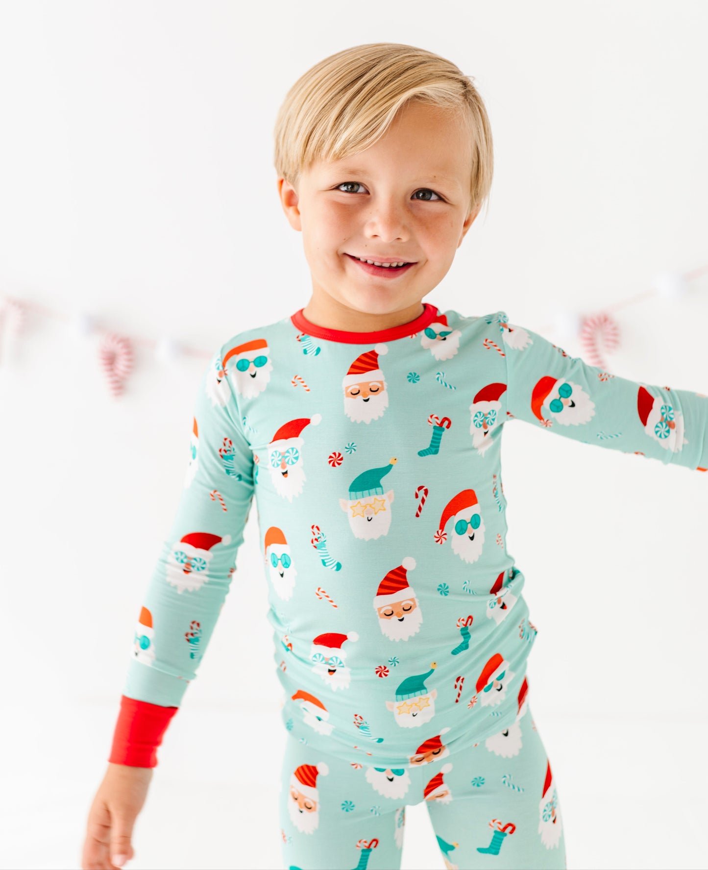 Child wearing a festive bamboo pajama set with Santa Claus design on a white background
