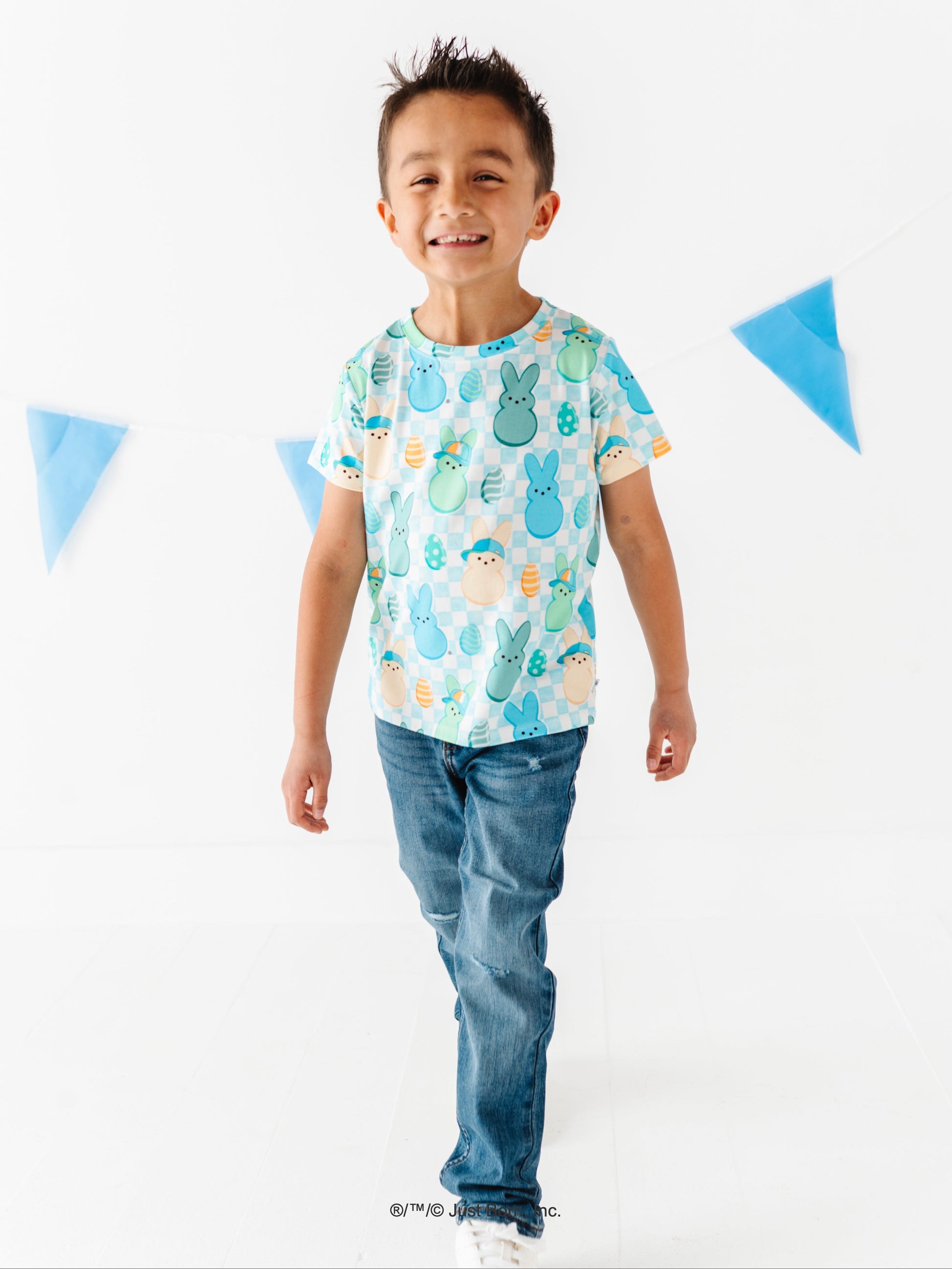 Child wearing a colorful t-shirt with a pattern of PEEPS® on a white background