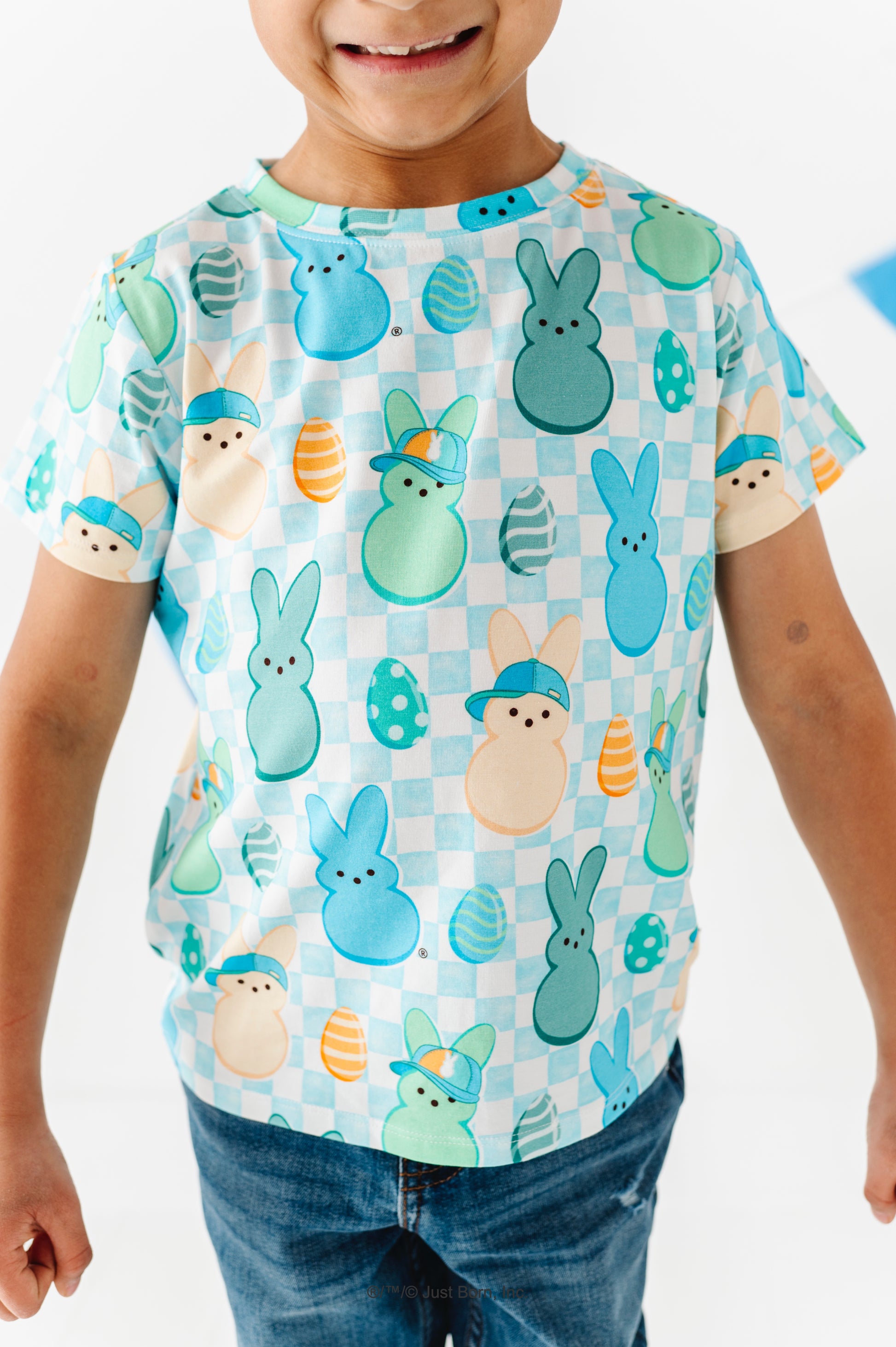 Child wearing a colorful t-shirt with PEEPS® pattern on a white background