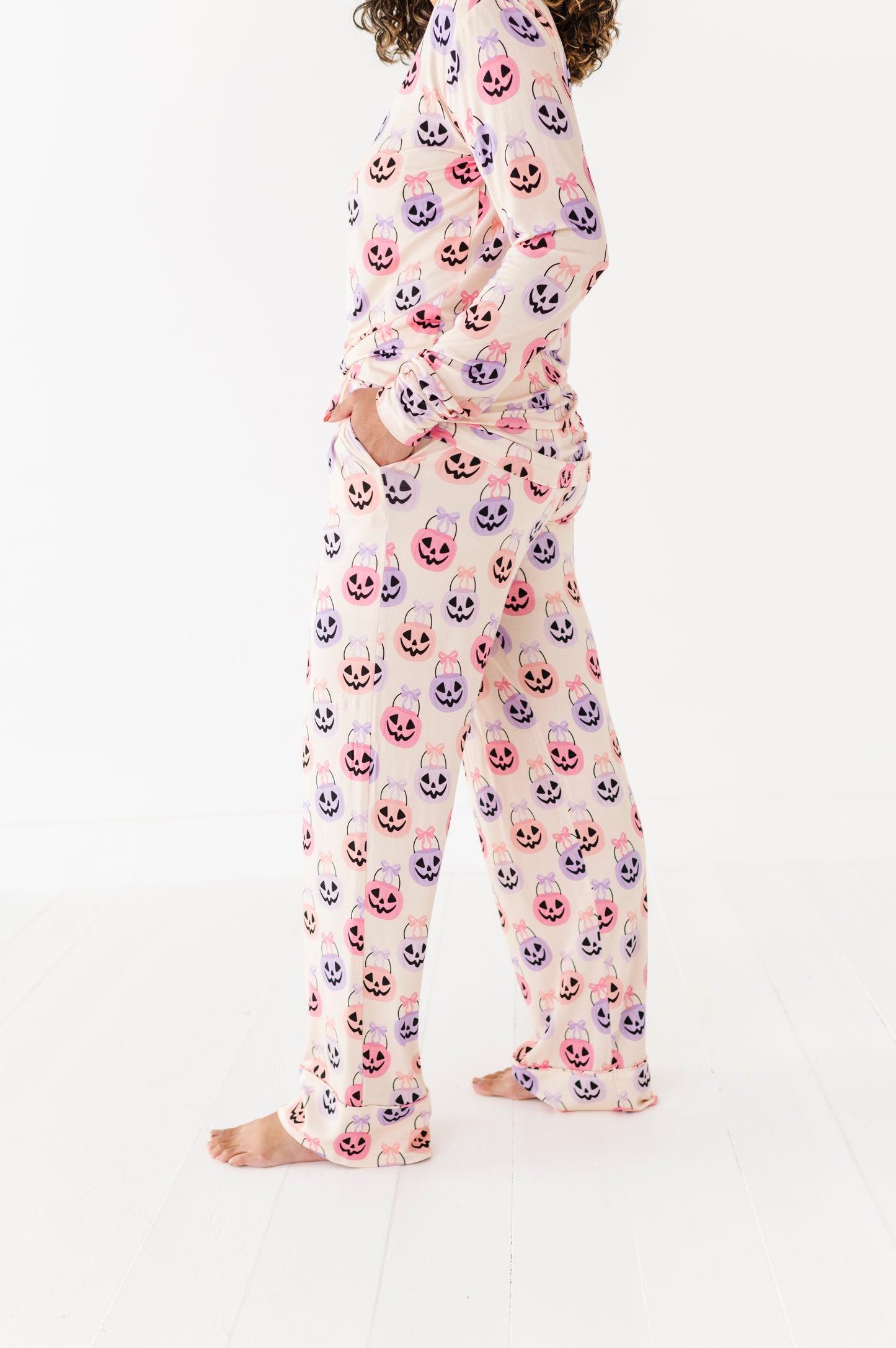 Woman wearing a bamboo pajama set with a Halloween-themed candy pattern on a white background