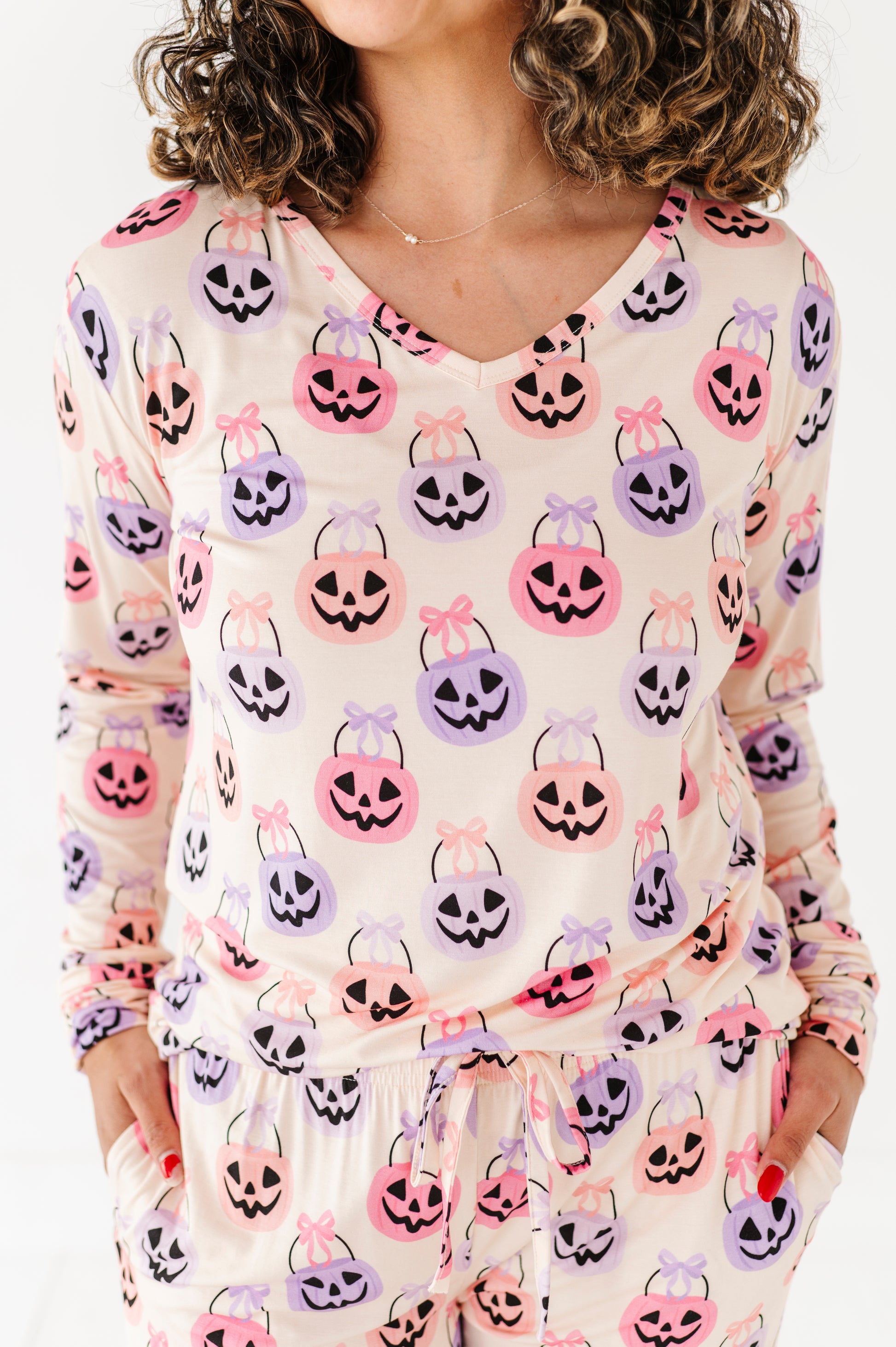 Woman wearing a long-sleeve bamboo pajama top with Halloween-themed candy bag print.