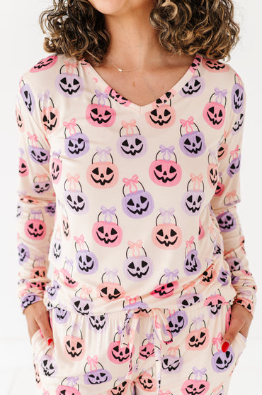 Woman wearing a long-sleeve bamboo pajama top with Halloween-themed candy bag print.