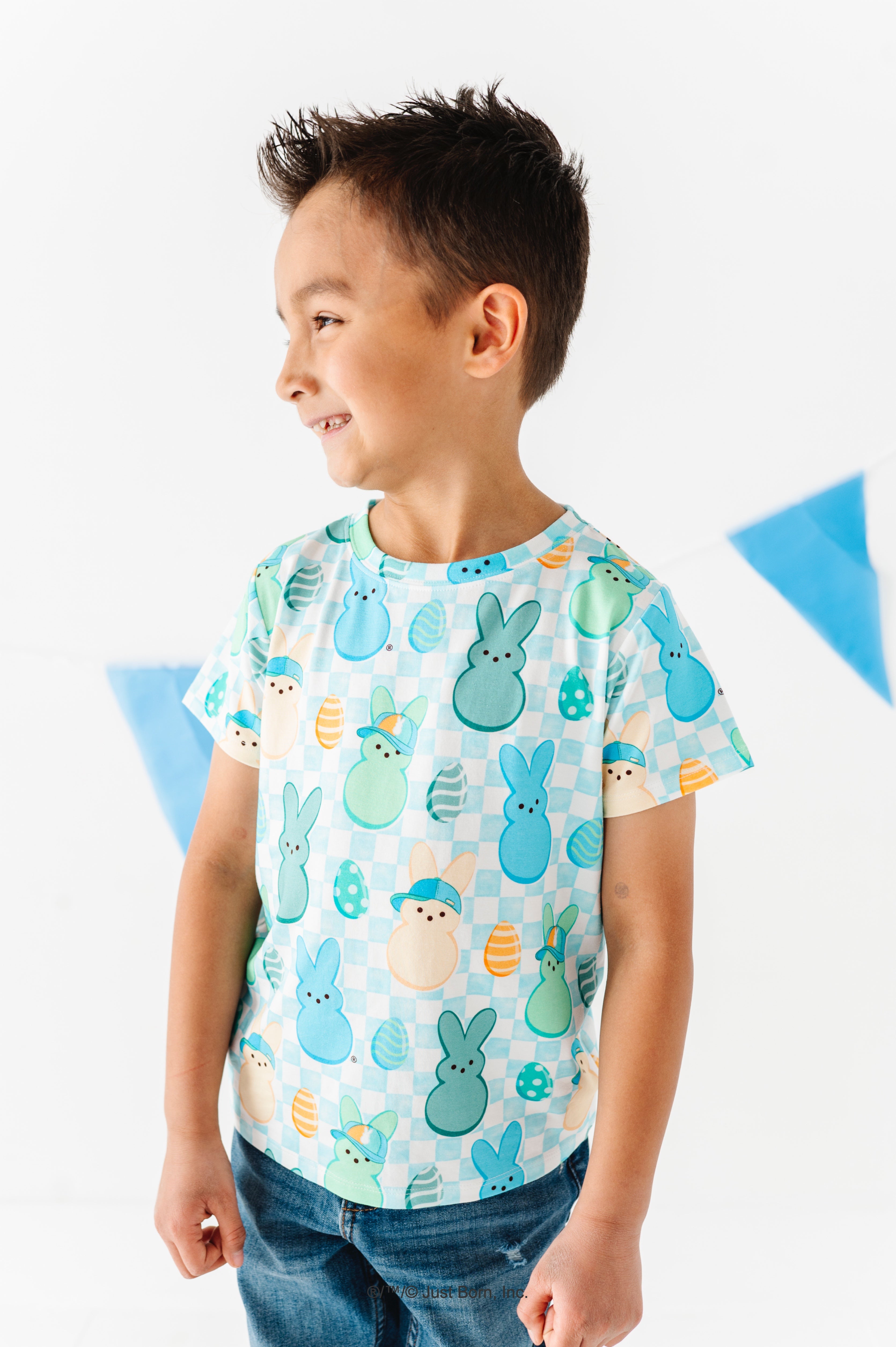 Child wearing a colorful t-shirt with PEEPS® print on a white background