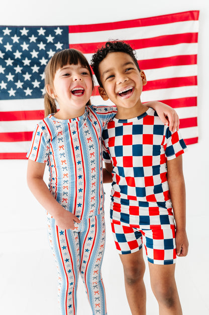 Brother and sister wearing coordinating bamboo pajama outfits in patriotic prints 