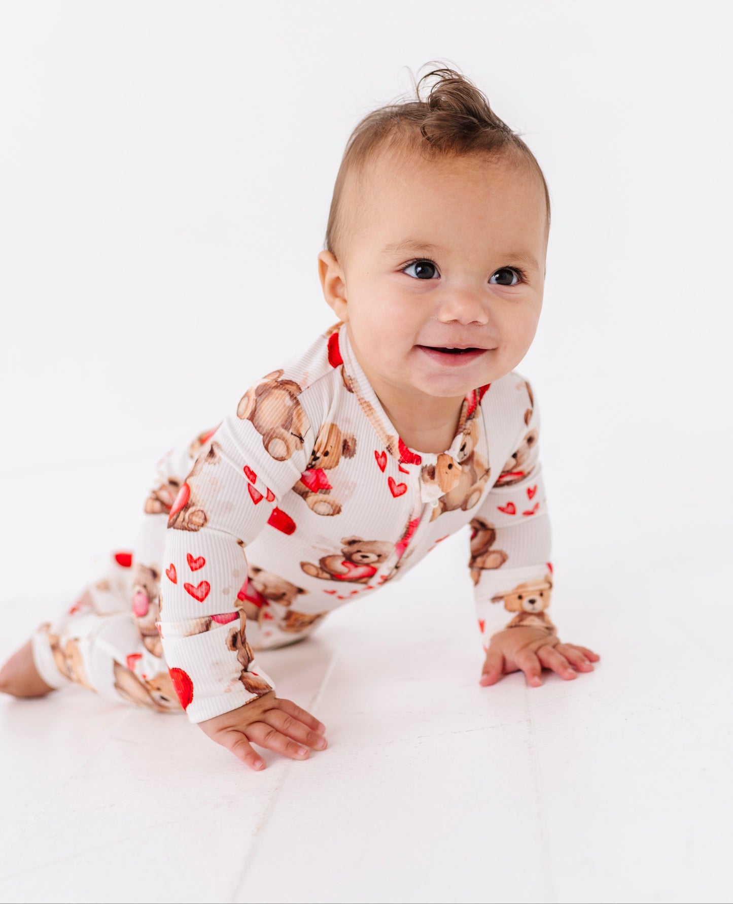 Baby crawling in bamboo viscose convertible footie romper with heart and teddy bear design