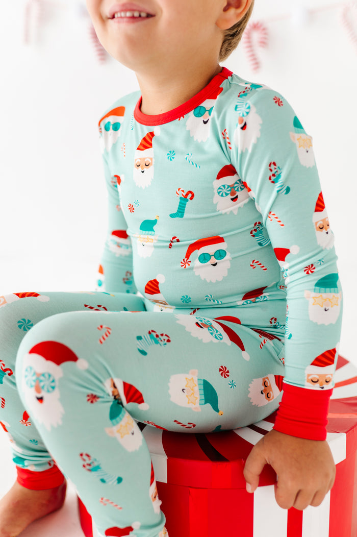 Child wearing a Christmas-themed bamboo pajama set with Santa Claus design on a white background.