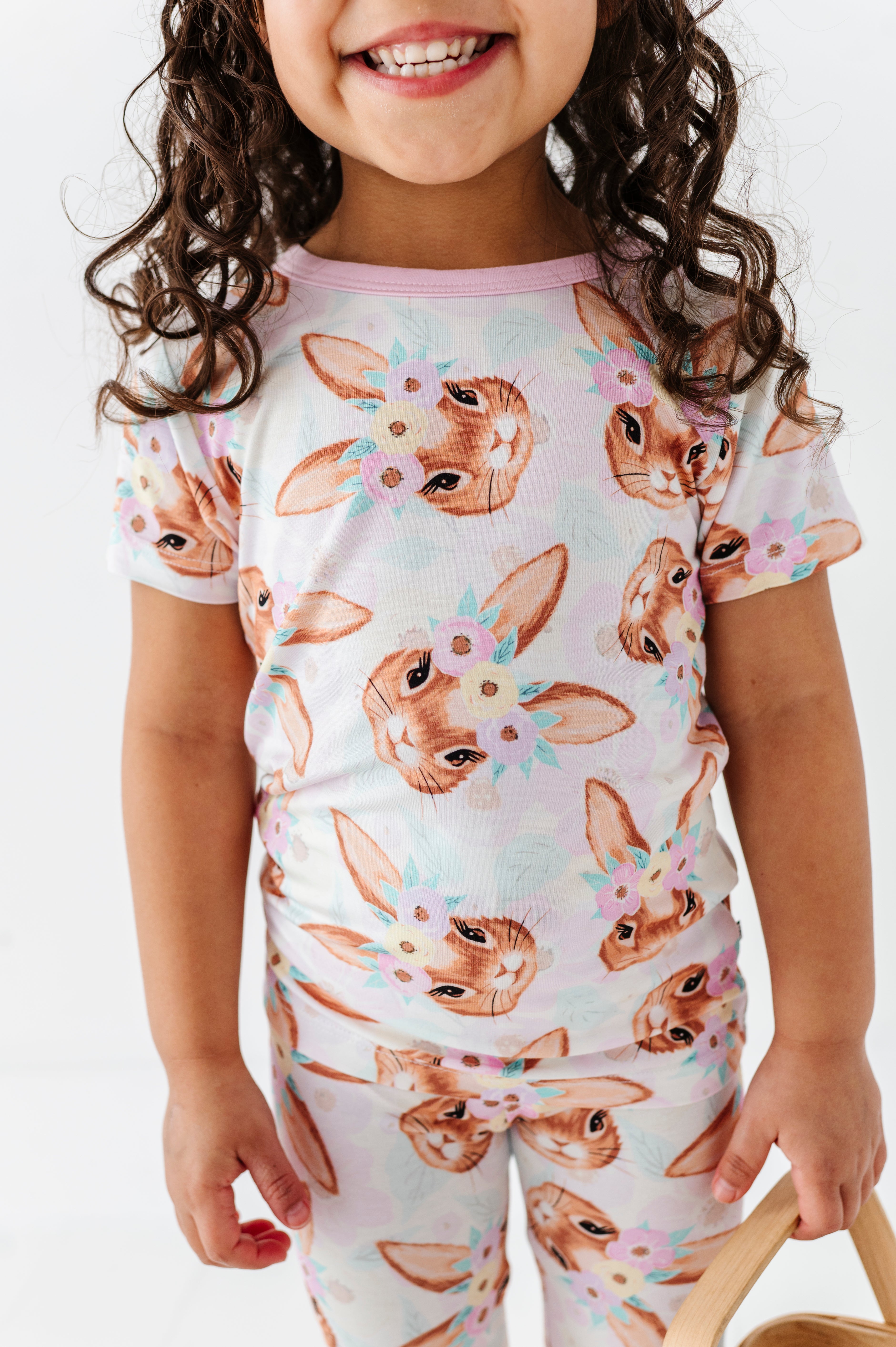 Child wearing a bamboo Easter pajama set with bunny print on a plain background