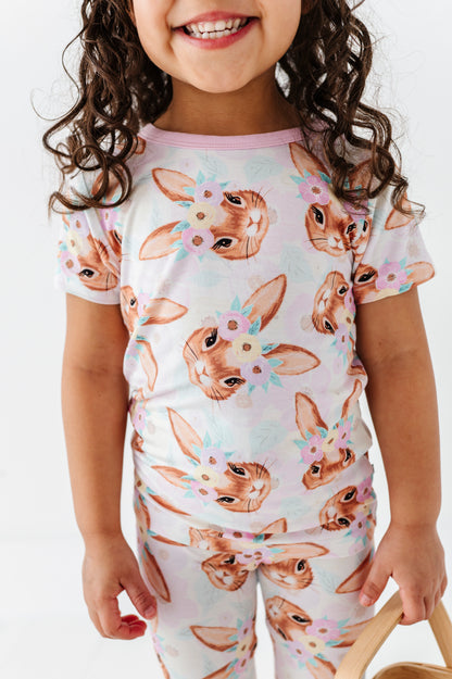 Child wearing a bamboo Easter pajama set with bunny print on a plain background
