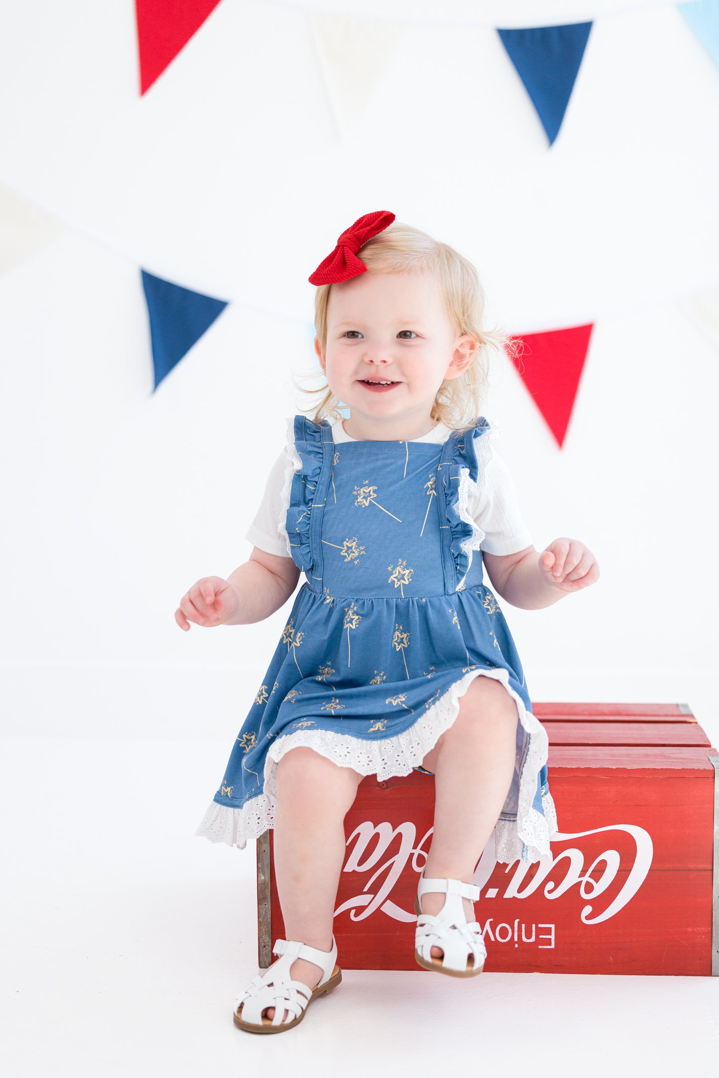 Baby girl wearing Sparkler Gold Foil Twirl Set holding an American flag
