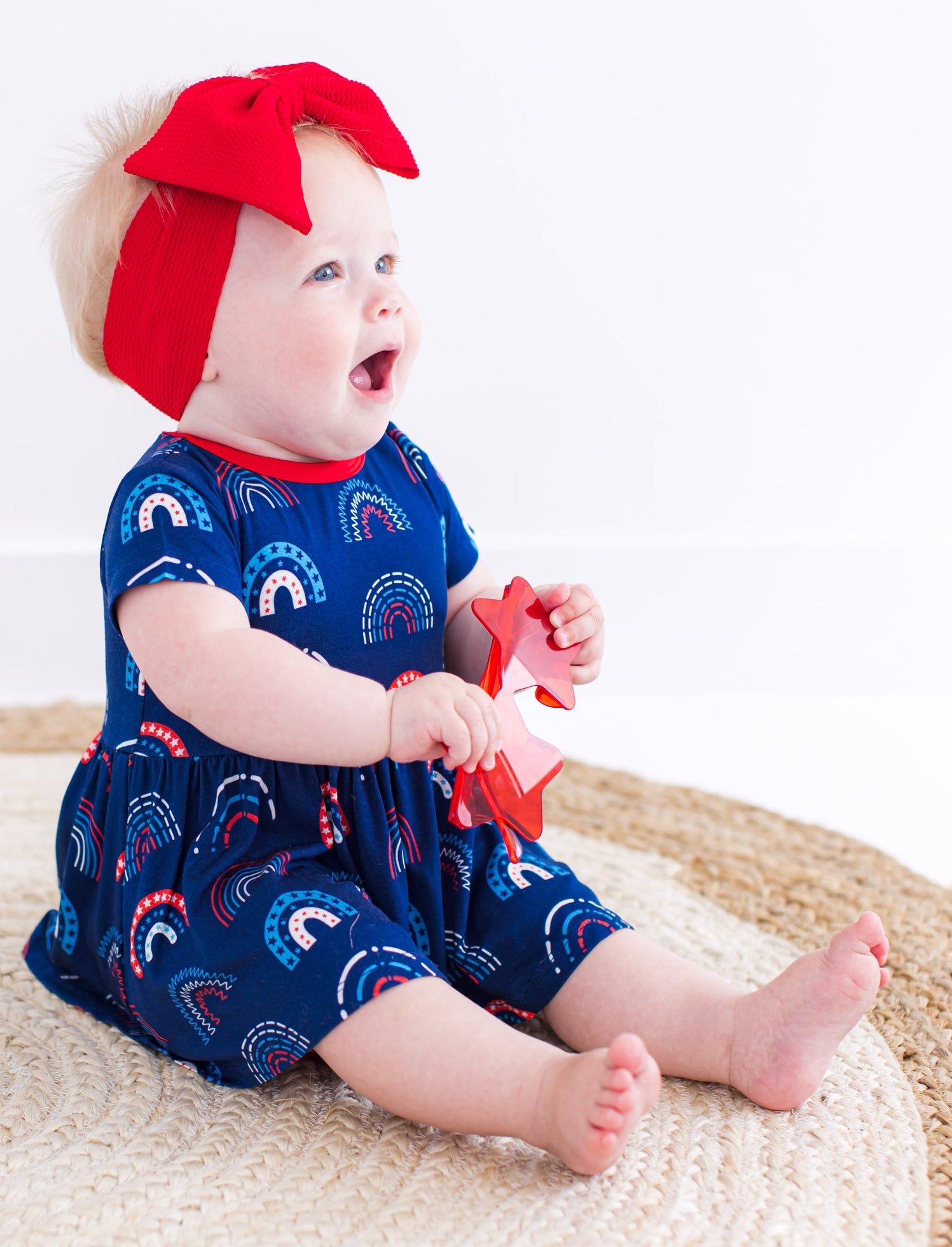 Child wearing a navy dress with red bow headband