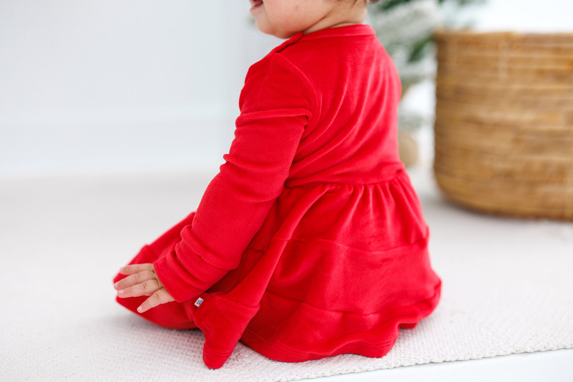 Baby girl sitting in a red velvet dress