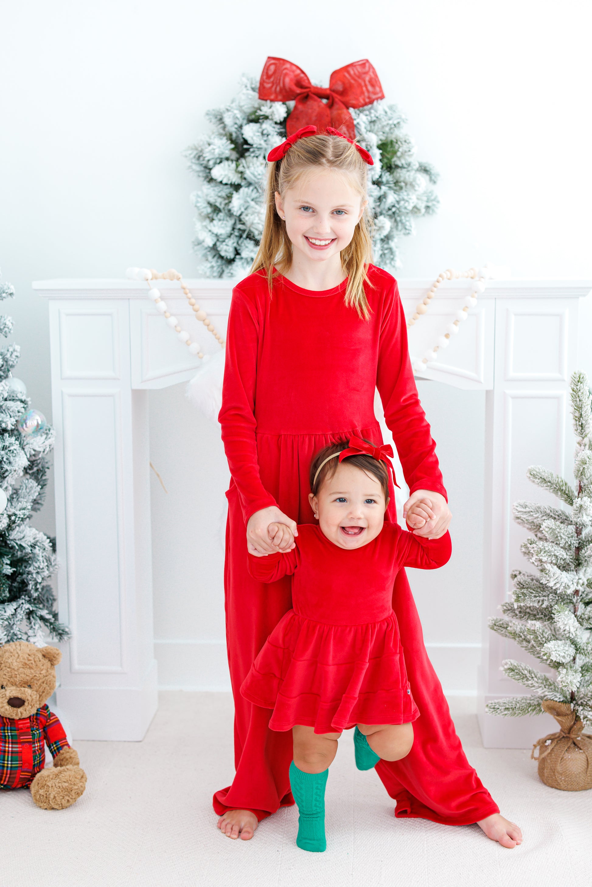 Sisters wearing matching red velvet styles for the holidays 