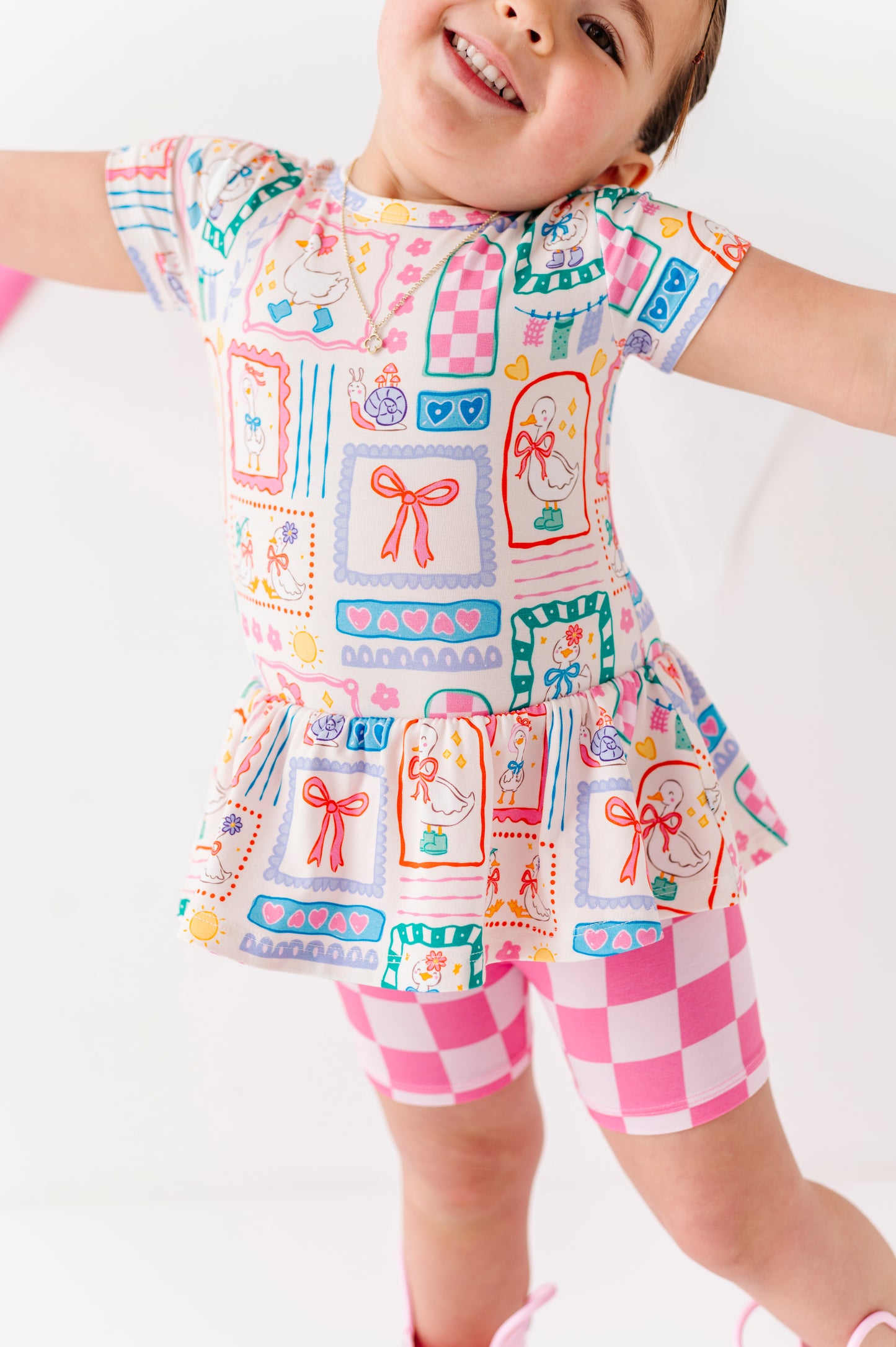 Child wearing a colorful bamboo/cotton outfit with patterns on a white background