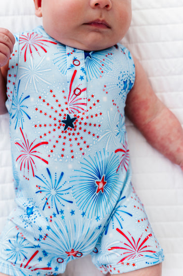 Baby wearing a bamboo shortie onesie with red, white, and blue firework pattern on a white background