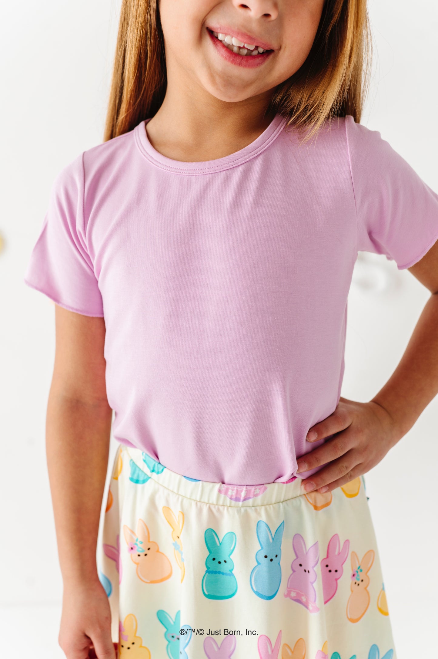 Child wearing a pink shirt and colorful PEEPS® bunny skirt on a white background