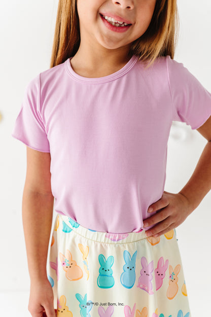Child wearing a pink shirt and colorful PEEPS® bunny skirt on a white background