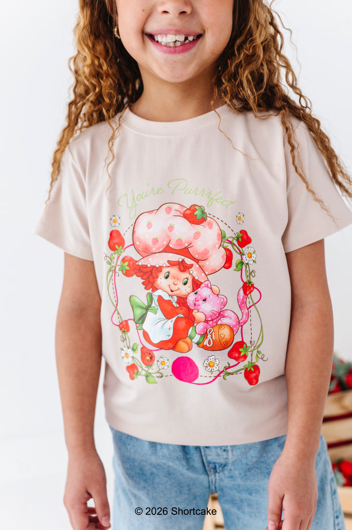 Child wearing a bamboo cotton Strawberry Shortcake™ t-shirt and light wash denim jeans