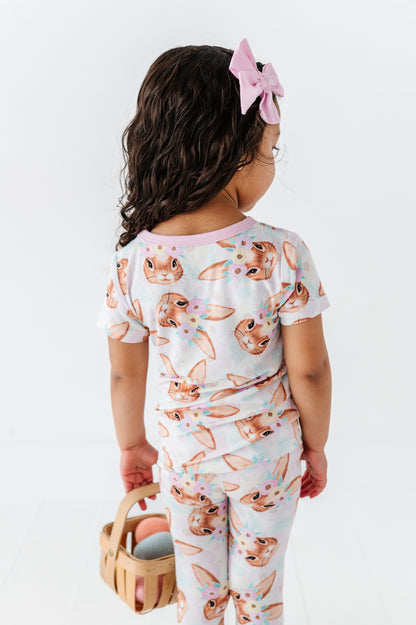 Child wearing an Easter bamboo pajama set with animal print on a white background