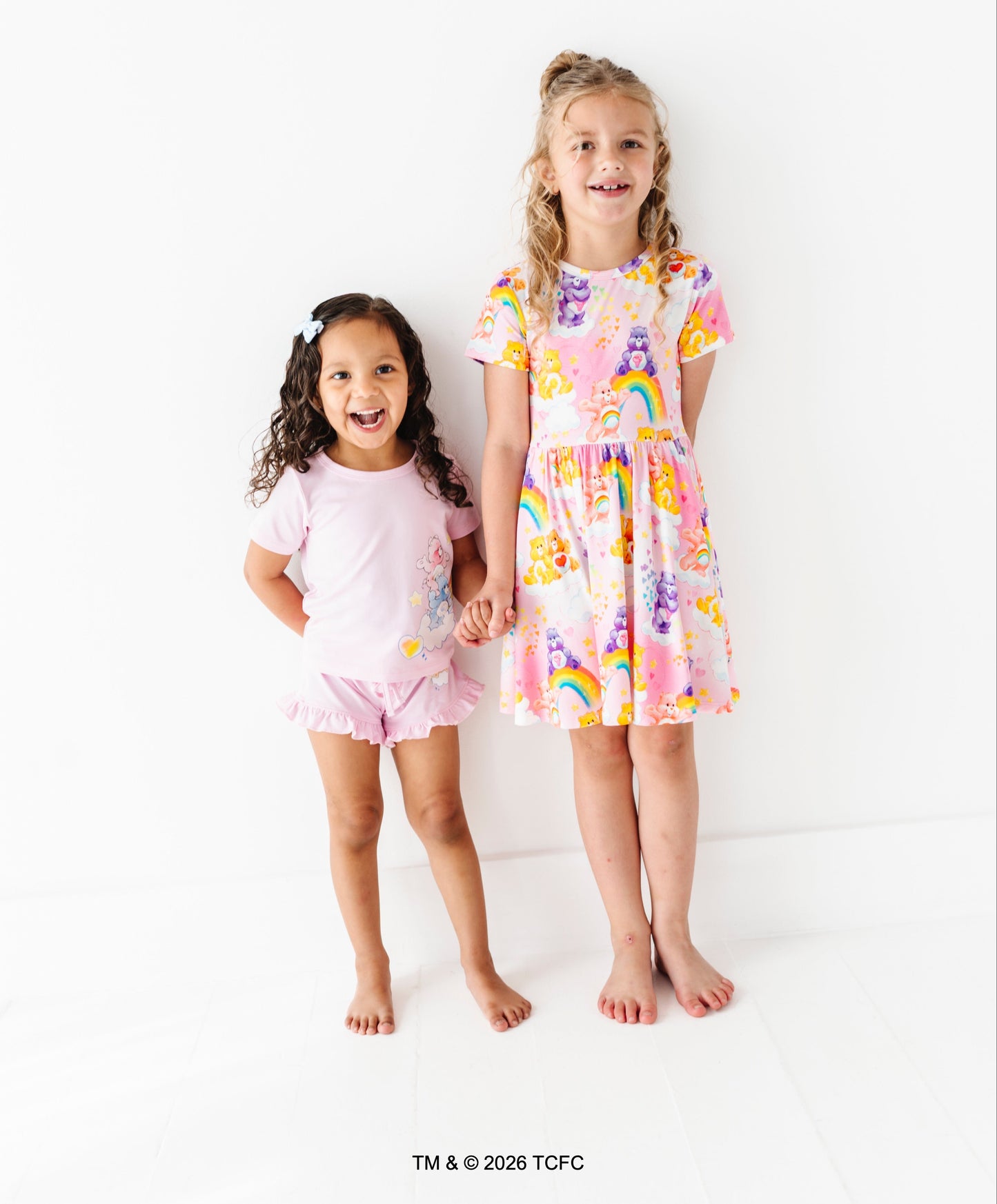 Two children wearing colorful Care Bears™ bamboo outfits standing against a white background