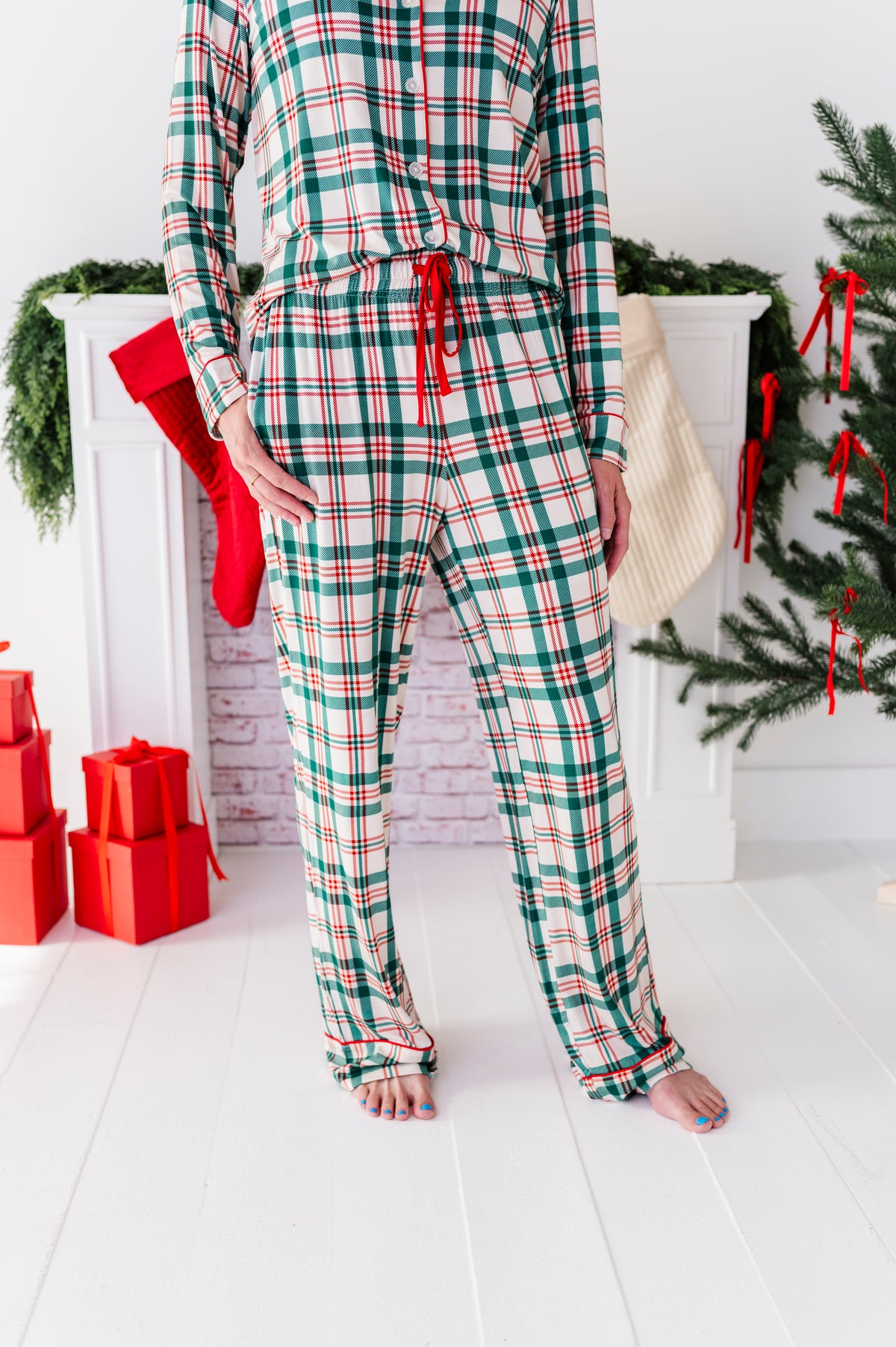 A close-up detail shot of a classic red-and-green Christmas plaid pajama set 