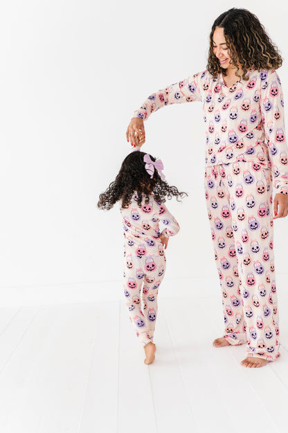Woman and child wearing matching bamboo pajamas with a Halloween pattern on a white background