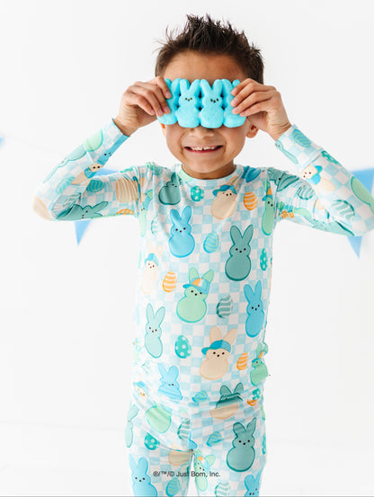Child wearing PEEPS® pajamas holding blue goggles over their eyes on a white background