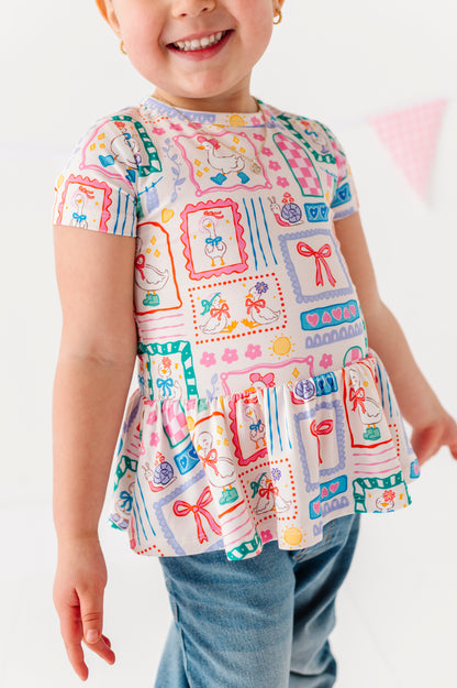 Child wearing a colorful patterned top with a white background