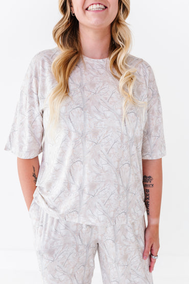 Woman wearing a light-colored patterned outfit on a white background