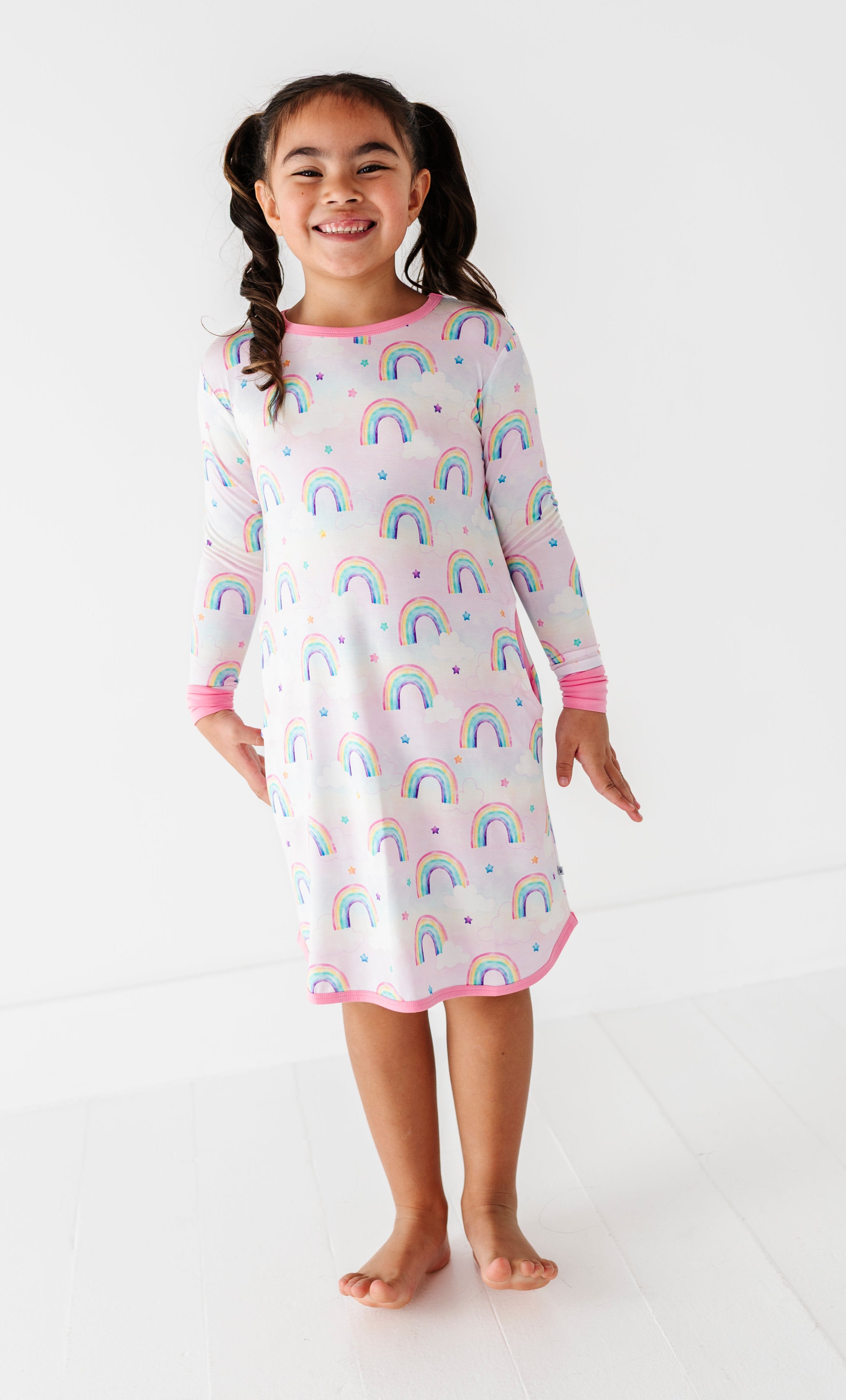Little girl wearing a Birdie gown for lounging, featuring watercolor rainbows on super soft bamboo fabric
