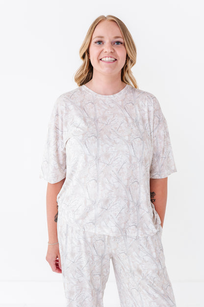 Woman wearing a camo patterned outfit on a white background
