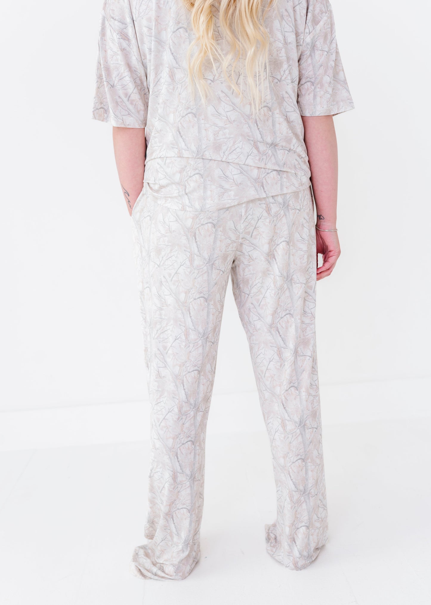 Person wearing a light-colored pajama set with a subtle pattern on a white background