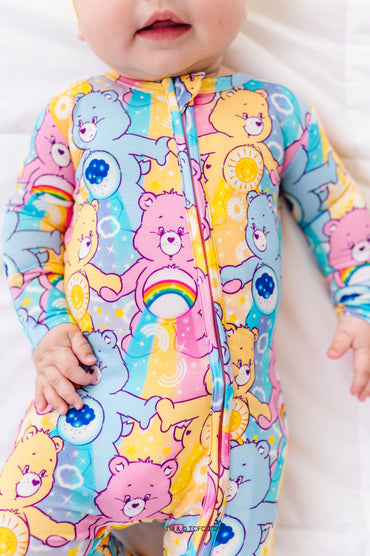 Close-up of Care Bears™ Stare bamboo romper showing vibrant Care Bears characters and rainbow belly badges
