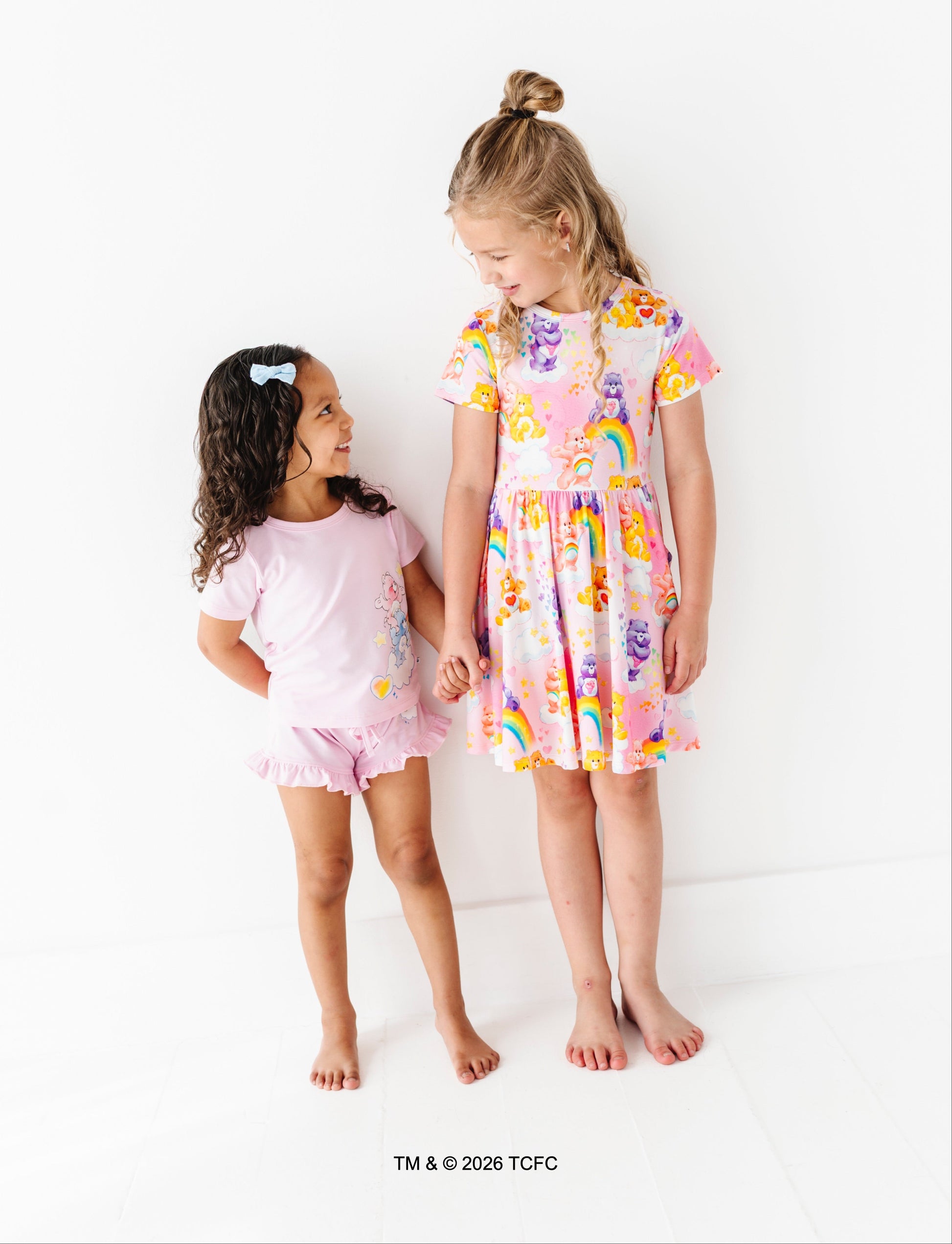 Two children wearing colorful bamboo Care Bears™ outfits standing against a white background