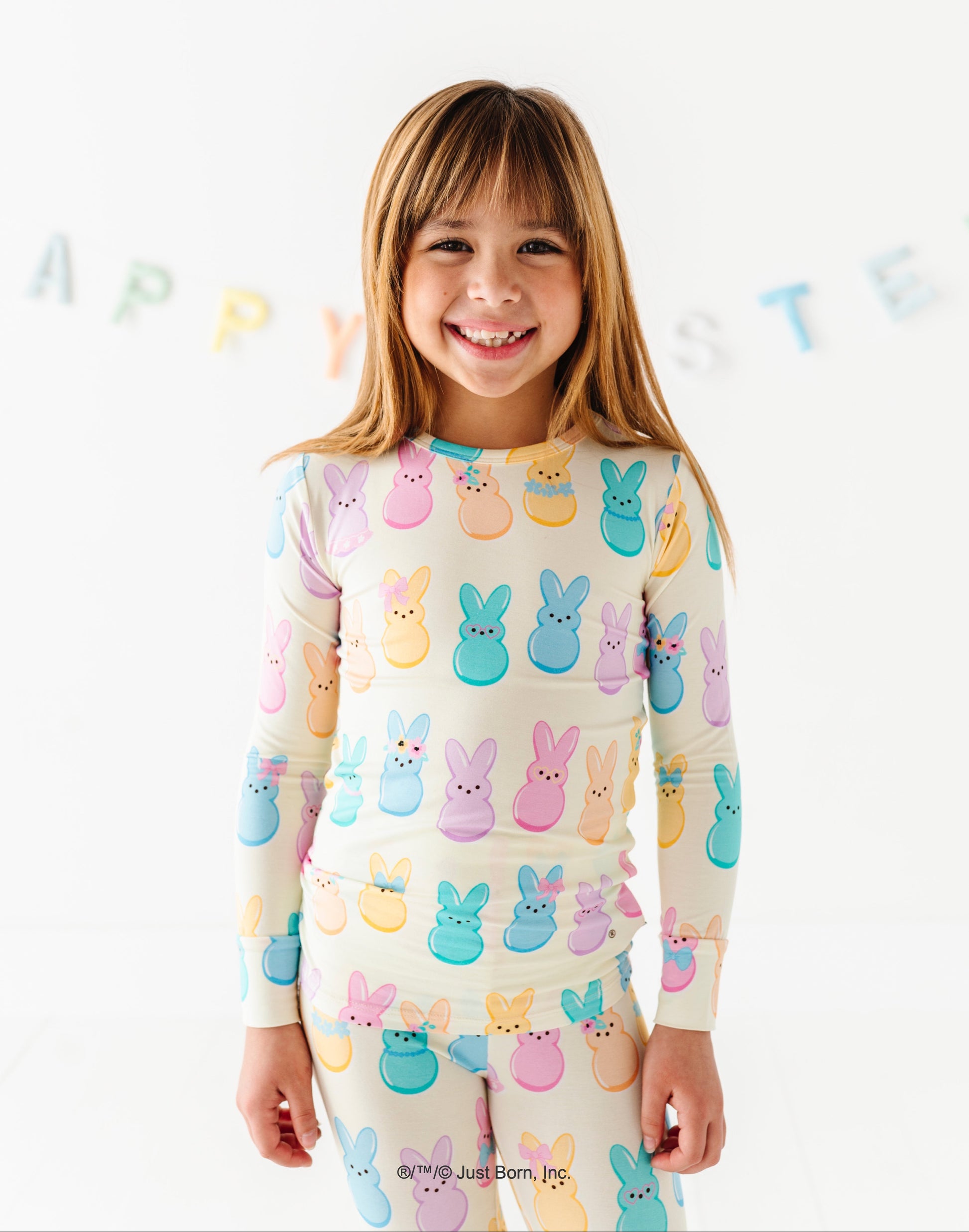 Child wearing a colorful Peeps-themed pajamas with a white background