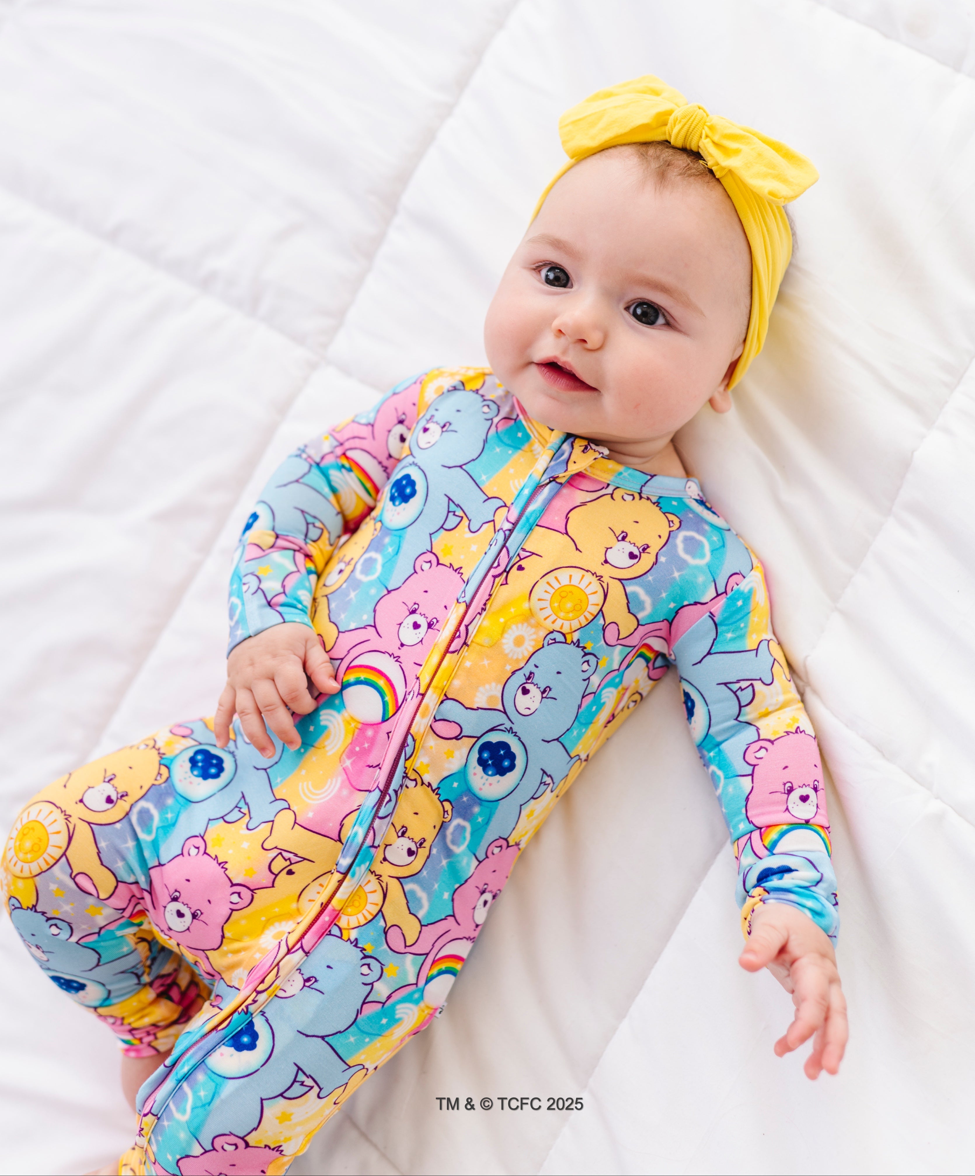 Baby wearing Care Bears™ Stare bamboo convertible romper with colorful allover Care Bears print