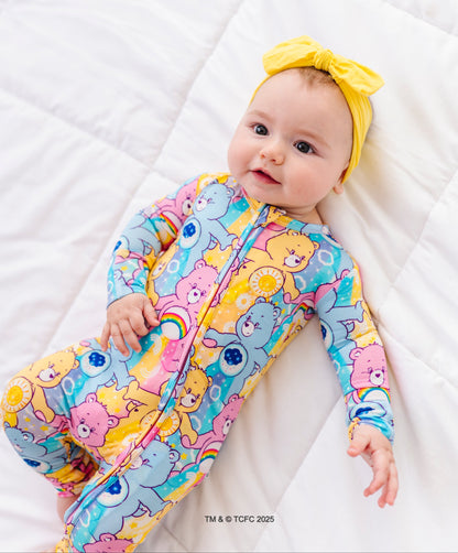 Baby wearing Care Bears™ Stare bamboo convertible romper with colorful allover Care Bears print