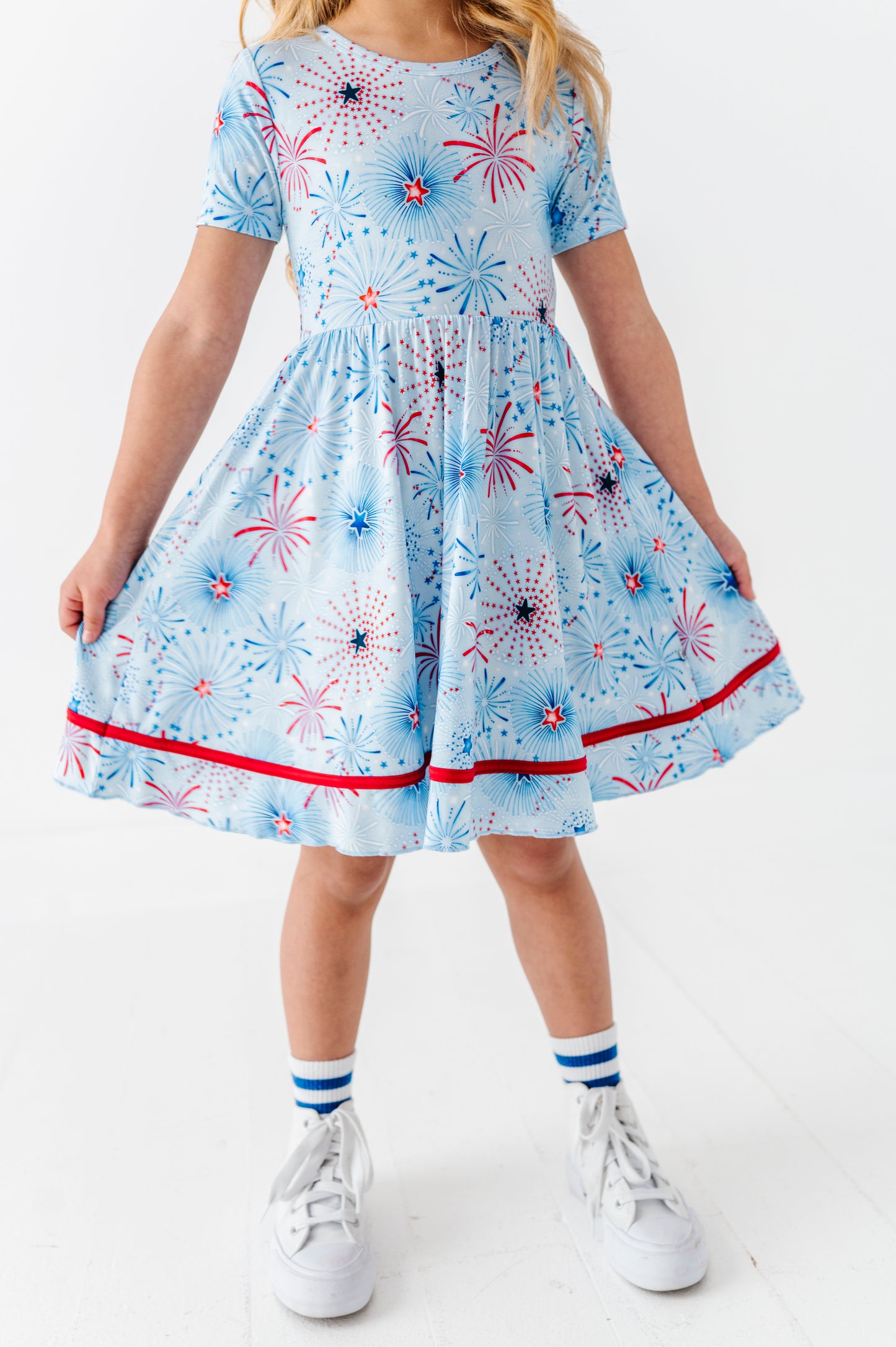 Child wearing a bamboo dress with a firework pattern on a white background