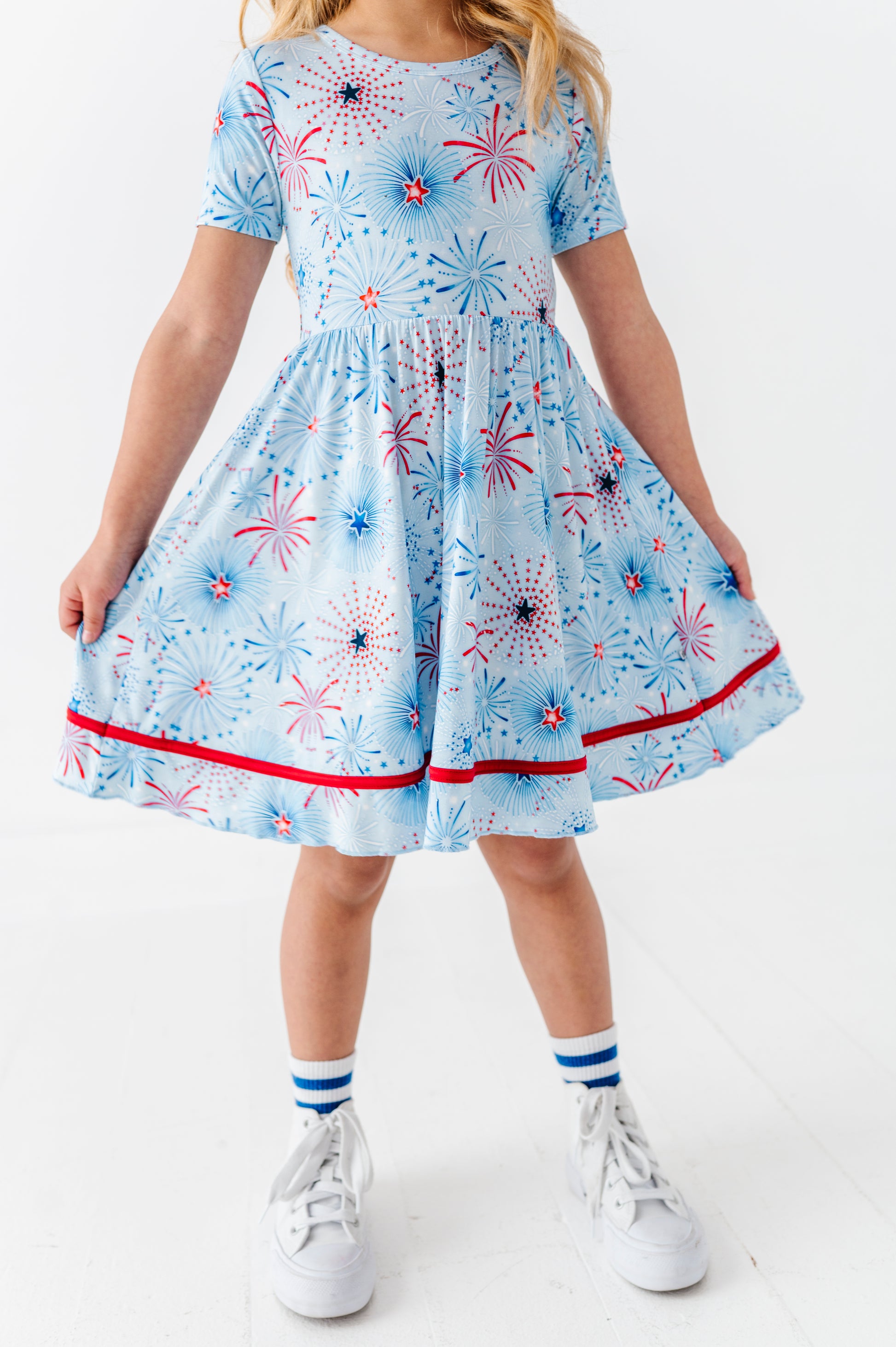 Child wearing a bamboo dress with a firework pattern on a white background