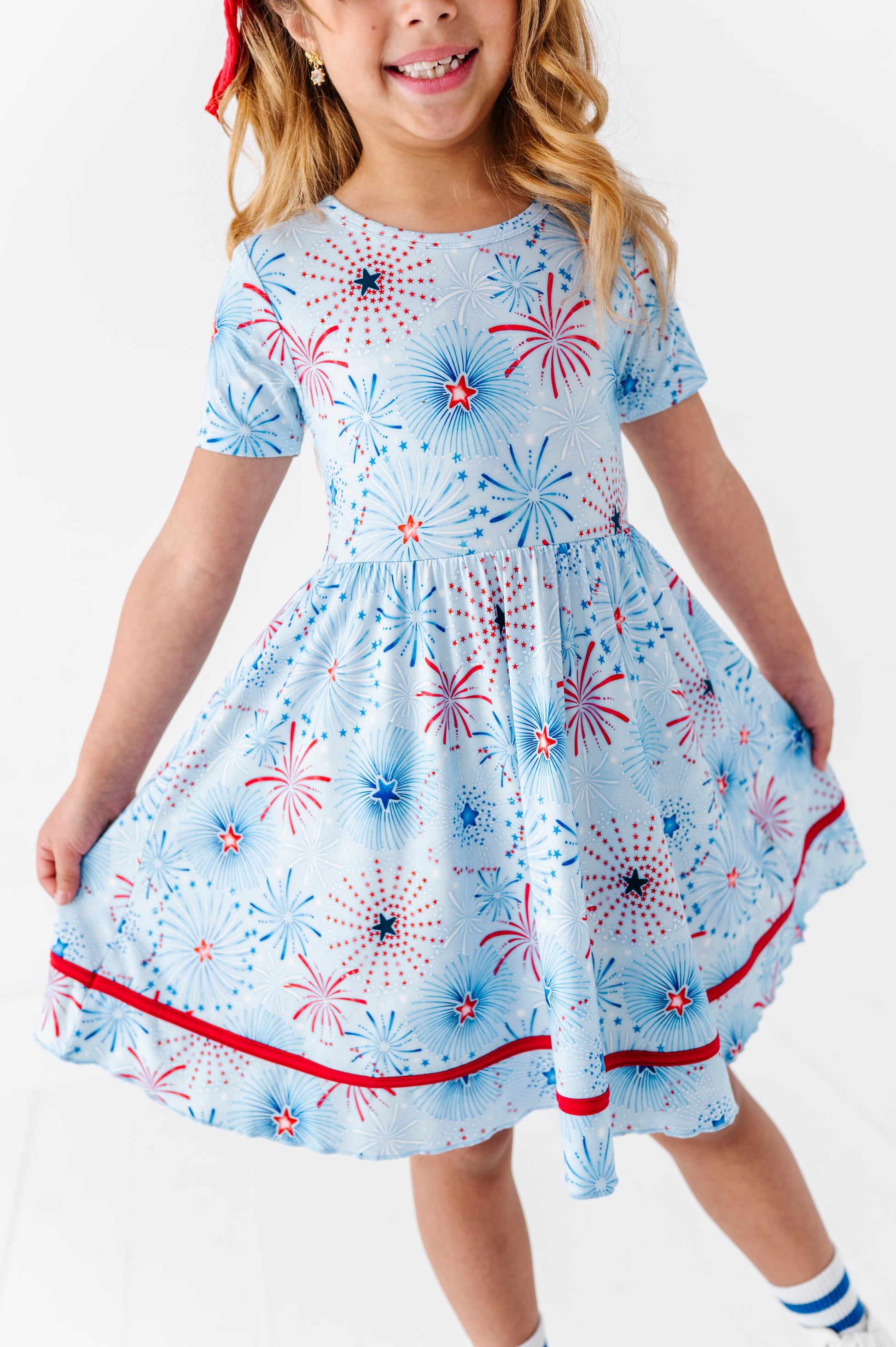 Child wearing a bamboo dress with fireworks pattern on a white background