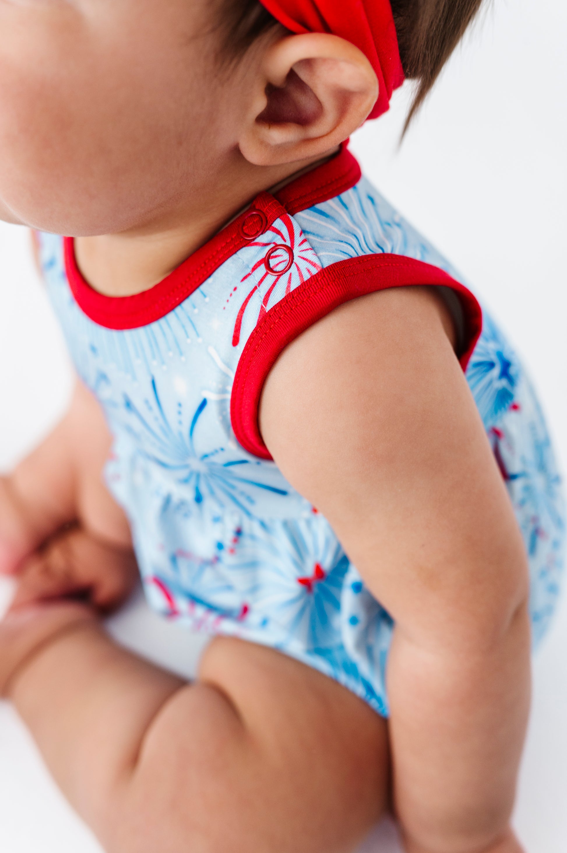 Baby wearing a red and white bamboo bubble romper with a blue pattern on a white background