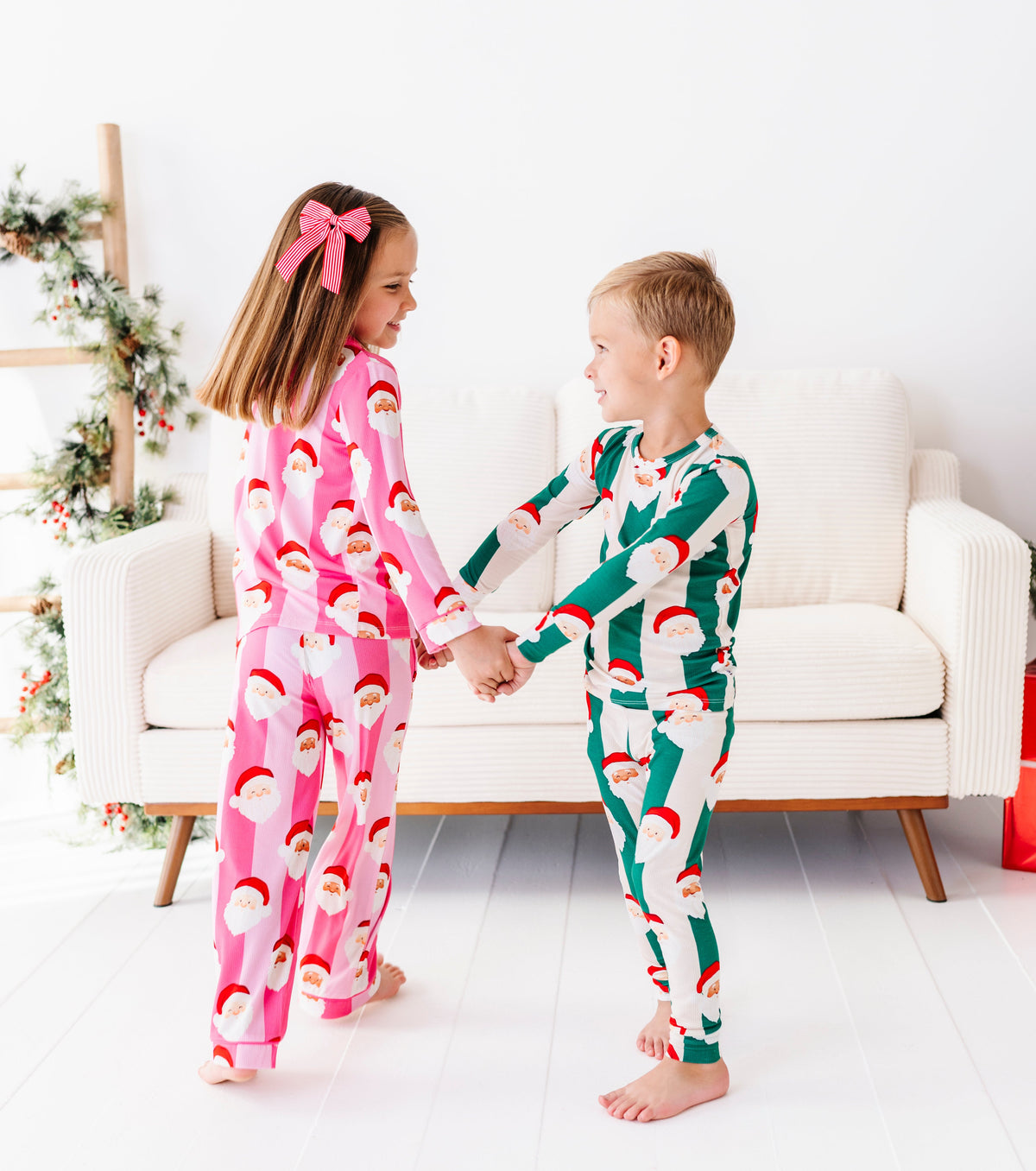 A brother and sister dancing together while wearing coordinating bamboo Christmas pajamas 