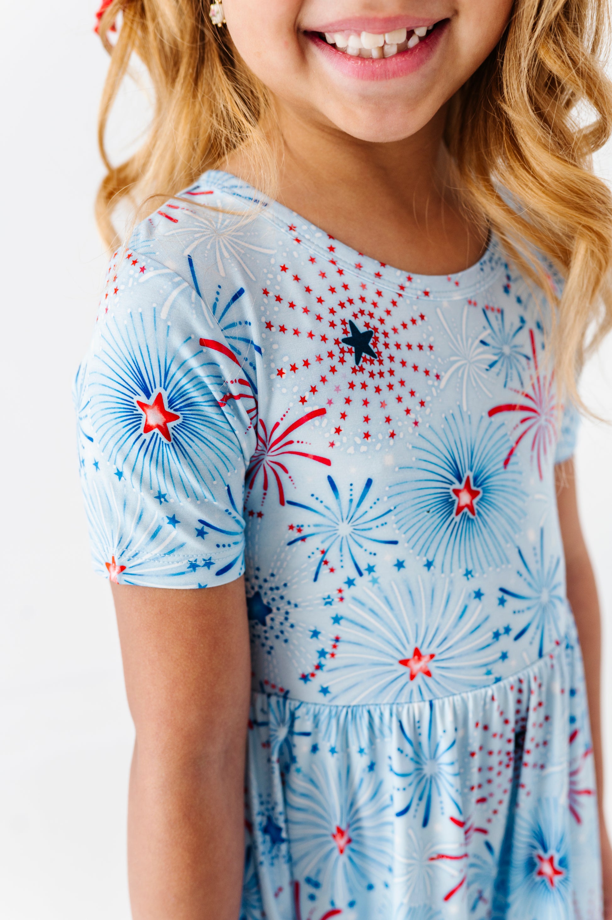 Child wearing a bamboo dress with fireworks pattern on a white background