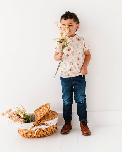 Child holding flowers next to a basket on a white background
