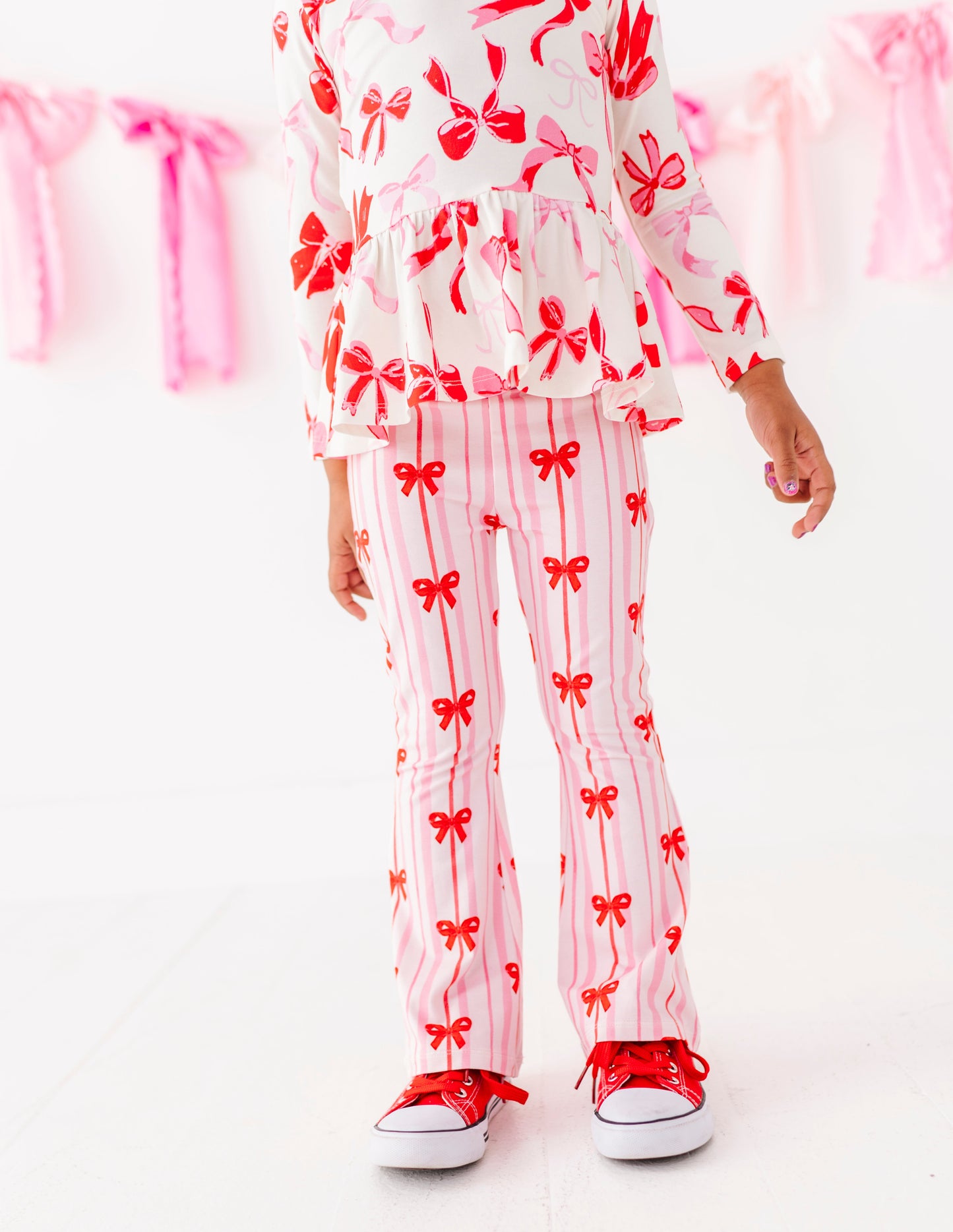 Pink striped bamboo cotton pants with red bow print on toddler