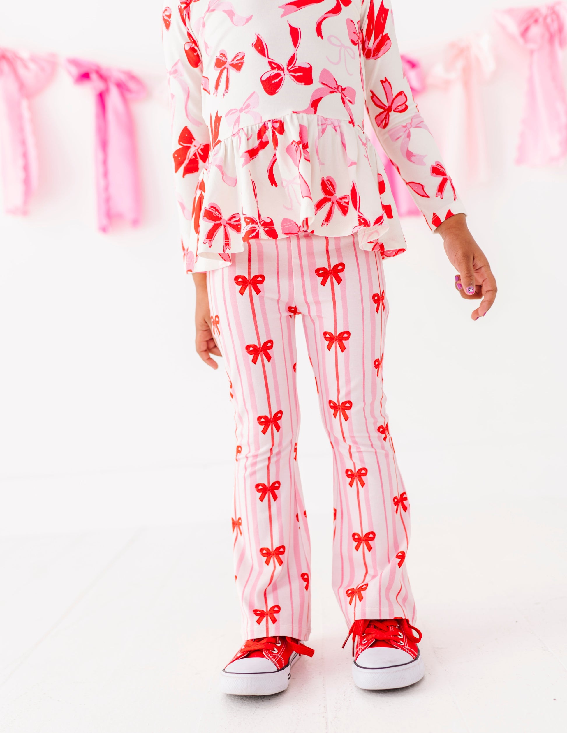 Pink striped bamboo cotton pants with red bow print on toddler