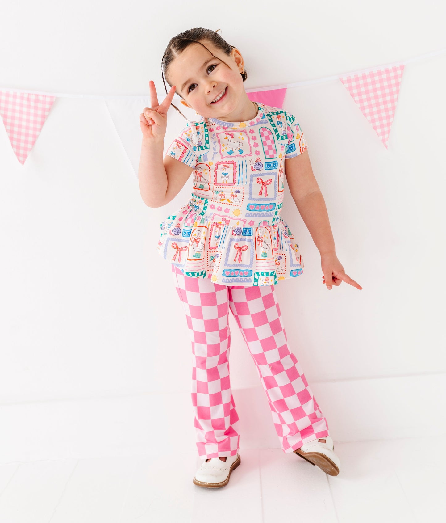 Child wearing a colorful bamboo outfit with a checkered pattern on a white background