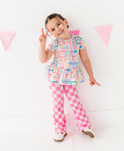 Child wearing a colorful outfit with a checkered pattern on a white background