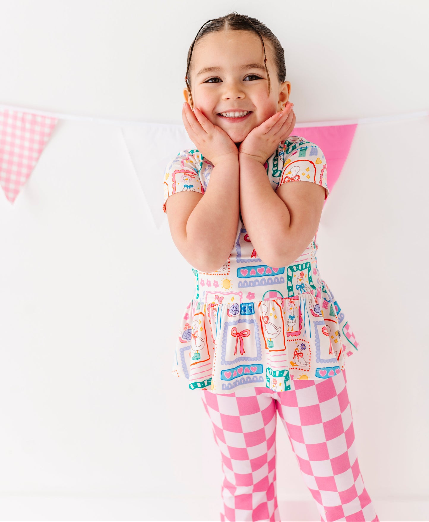 Child wearing a colorful bamboo outfit with a checkered pattern on a white background